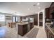 Open concept kitchen and dining area featuring stainless steel appliances, a large island, and dark wood cabinets at 7538 Mustang St, Las Vegas, NV 89131