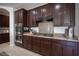Close up of the kitchen, featuring stainless steel appliances, dark cabinets, and a gas cooktop at 7538 Mustang St, Las Vegas, NV 89131