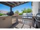 An outdoor kitchen with stainless steel grill, mini-fridge, and countertop space under a pergola, great for entertaining at 7538 Mustang St, Las Vegas, NV 89131