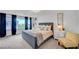 Luxurious primary bedroom with large window, plush carpet, designer chair, and elegant furnishings at 7756 Seville Estates Ct, Las Vegas, NV 89113