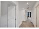 Well-lit hallway with carpeted floor, white doors, and direct access to bedrooms at 7756 Seville Estates Ct, Las Vegas, NV 89113