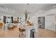 Bright and airy living room showcasing open floor plan, wood floors, neutral decor, and seamless flow to kitchen and stairs at 7756 Seville Estates Ct, Las Vegas, NV 89113