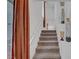 View of a carpeted staircase with white railings, ascending towards a well-lit landing and upper level of the home at 7756 Seville Estates Ct, Las Vegas, NV 89113