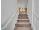 View of a carpeted staircase with white railings, ascending towards a well-lit landing and upper level of the home at 7756 Seville Estates Ct, Las Vegas, NV 89113