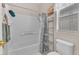 Clean bathroom with a tub-shower, white tile, and shelving unit at 7852 Running Doe Ct, Las Vegas, NV 89149
