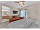 Bright bedroom featuring a large television, wood furniture, and comfortable bedding at 7852 Running Doe Ct, Las Vegas, NV 89149