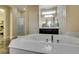 Bathroom featuring a jacuzzi tub, glass shower, and a large mirror over the vanity at 7998 W Ford Ave, Las Vegas, NV 89113