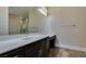 Bathroom featuring quartz countertops, dark wood cabinets, and a large mirror over the vanity at 7998 W Ford Ave, Las Vegas, NV 89113