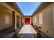 The front entryway, adorned with lush potted plants, leads to striking red double doors and invites visitors inside at 7998 W Ford Ave, Las Vegas, NV 89113