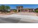 A sprawling home featuring a three-car garage, desert landscaping, and unique architectural elements at 7998 W Ford Ave, Las Vegas, NV 89113