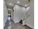 Long hallway with hardwood floors leads to a stairway, featuring a modern banister and neutral walls at 7998 W Ford Ave, Las Vegas, NV 89113