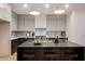 Gorgeous island kitchen with modern appliances, grey cabinetry, and a large island with seating at 8104 Bay Harbor Dr, Las Vegas, NV 89128