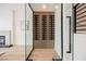 Contemporary wine cellar with wood paneling and glass enclosure is an elegant focal point at 8104 Bay Harbor Dr, Las Vegas, NV 89128