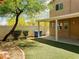 Charming backyard with artificial grass, covered patio, mature landscaping, and privacy fence at 8550 Bright Bush St, Las Vegas, NV 89131