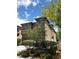 Tan two story home with a two car garage and landscaping including small trees and bushes under a partly cloudy sky at 8550 Bright Bush St, Las Vegas, NV 89131
