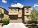 Two story home with tan stucco, a two-car garage and a concrete driveway under a partly cloudy sky at 8550 Bright Bush St, Las Vegas, NV 89131