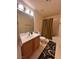Neutral bathroom with a shower-tub combo, wood vanity and framed mirror provide a relaxing and convenient experience at 87 E Agate Ave # 202, Las Vegas, NV 89123