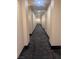 Long hallway with patterned carpet and neutral-colored walls and trim at 87 E Agate Ave # 202, Las Vegas, NV 89123