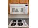 Kitchen featuring a white microwave, granite countertops, and a four-burner gas stovetop at 87 E Agate Ave # 202, Las Vegas, NV 89123