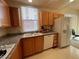 Functional kitchen featuring oak cabinets, granite counters, and updated appliances at 87 E Agate Ave # 202, Las Vegas, NV 89123