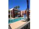 Community pool with clear blue water, lounge chairs, and palm trees against blue sky at 87 E Agate Ave # 202, Las Vegas, NV 89123