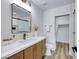 Modern bathroom features wood vanity, gold fixtures, framed mirror, with a glass enclosed shower at 9078 Hilverson Ave, Las Vegas, NV 89148