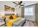 Inviting bedroom with soft yellow accents, decorative ceiling fan, and a bright window at 9078 Hilverson Ave, Las Vegas, NV 89148