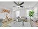 Bright living room featuring a ceiling fan, neutral sofa, large windows, and modern decor at 9078 Hilverson Ave, Las Vegas, NV 89148