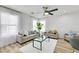 Bright living room featuring neutral furniture, wood floors, ceiling fan and many windows at 9078 Hilverson Ave, Las Vegas, NV 89148