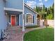 Inviting front porch with a red door, brick pathway, well-maintained lawn, and lovely landscaping at 9436 Darwell Dr, Las Vegas, NV 89117