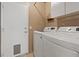 Functional laundry room with modern washer and dryer units, door to side yard at 9436 Darwell Dr, Las Vegas, NV 89117