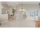 Open-concept living area featuring a staircase, neutral tile flooring, and ample natural light from large windows at 9436 Darwell Dr, Las Vegas, NV 89117