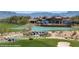 Community pool with mountains in the background, a pond with waterfalls, and a lush golf course at 977 Majestic Vw, Mesquite, NV 89034