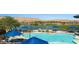 A luxurious community pool area featuring blue umbrellas with the mountains and golf course in the distance at 977 Majestic Vw, Mesquite, NV 89034
