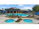 Beautiful community pool with two hot tubs surrounded by desert landscaping and blue umbrellas at 977 Majestic Vw, Mesquite, NV 89034