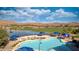 Community pool with lounge seating with views of the surrounding desert landscape and golf course at 977 Majestic Vw, Mesquite, NV 89034