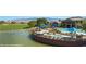 Community pool, lounge chairs, umbrellas, and ponds with beautiful mountain views in the background at 977 Majestic Vw, Mesquite, NV 89034