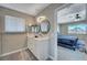 Bright bathroom features a double sink vanity, contemporary lighting, and a glimpse into the adjacent bedroom at , Henderson, NV 89014