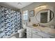 Bathroom featuring modern lighting and a marble-top vanity with a sink, toilet, and patterned shower curtain at , Henderson, NV 89014
