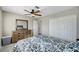 Bright bedroom featuring a ceiling fan, dresser, window, and double door closet at , Henderson, NV 89014