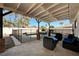 Relaxing covered patio featuring string lights, poolside seating, and a secure safety fence at , Henderson, NV 89014