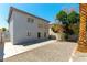 Back exterior of a two-story house with a gravel backyard, trees and a concrete patio at 10162 Lemon Thyme St, Las Vegas, NV 89183