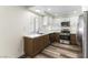 Kitchen with white upper cabinets and wood-tone lower cabinets and stainless steel appliances at 10162 Lemon Thyme St, Las Vegas, NV 89183