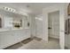 Spacious bathroom with double vanity, large mirror, glass-enclosed shower, and linen closet for ample storage at 10345 Zebra Swallowtail St, Las Vegas, NV 89141
