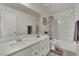 Stylish bathroom featuring a single sink vanity with an oversized mirror, bathtub, and modern fixtures at 10345 Zebra Swallowtail St, Las Vegas, NV 89141
