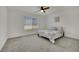 Bright bedroom with a large window, soft gray carpet, and a ceiling fan providing a comfortable living space at 10345 Zebra Swallowtail St, Las Vegas, NV 89141