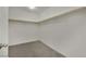 Walk-in closet features white walls, carpet flooring and wooden clothes rods, perfect for organized storage at 10345 Zebra Swallowtail St, Las Vegas, NV 89141