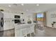 Open-concept kitchen with white cabinets, stainless steel appliances, and an island with seating at 10345 Zebra Swallowtail St, Las Vegas, NV 89141