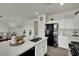 Bright kitchen featuring an island with a sink, black appliances, and white cabinetry at 10345 Zebra Swallowtail St, Las Vegas, NV 89141