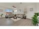 Inviting living room with wood-look tile floors, neutral furniture, and ample natural light at 10345 Zebra Swallowtail St, Las Vegas, NV 89141